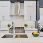 A delta kitchen faucet in a large white kitchen