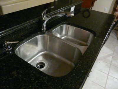 Two gauge stainless steel sinks with a stainless steel faucet